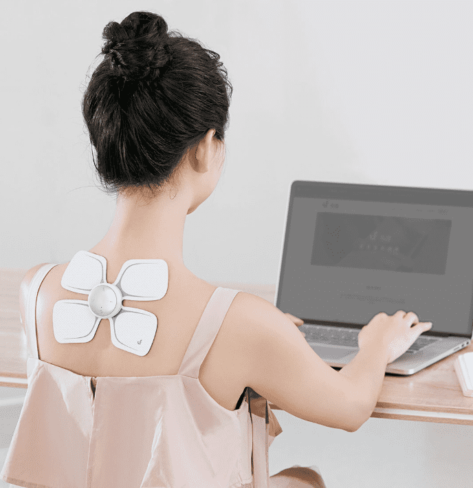 Девушка с портативным массажером Xiaomi LeFan за компьютером